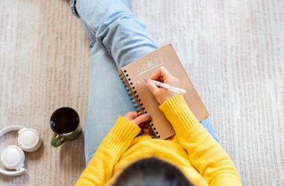woman writing goals in a book