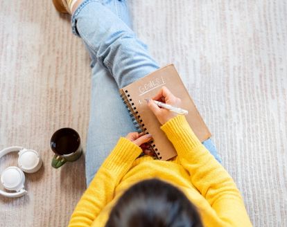 woman writing goals in a book